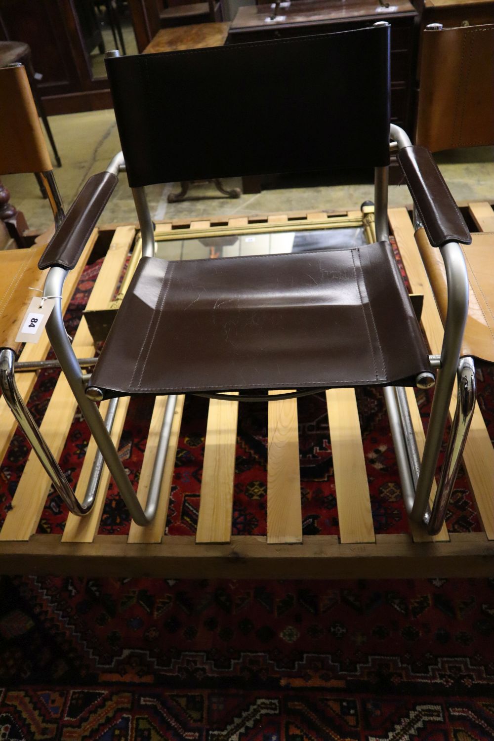 Three mid century design tubular metal and leather cantilever chairs